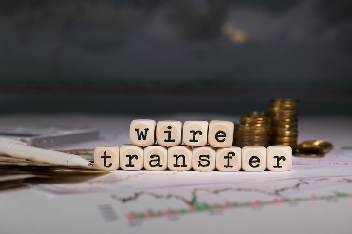 Words WIRE TRANSFER composed of wooden letter. Denver-wire-fraud-lawyers